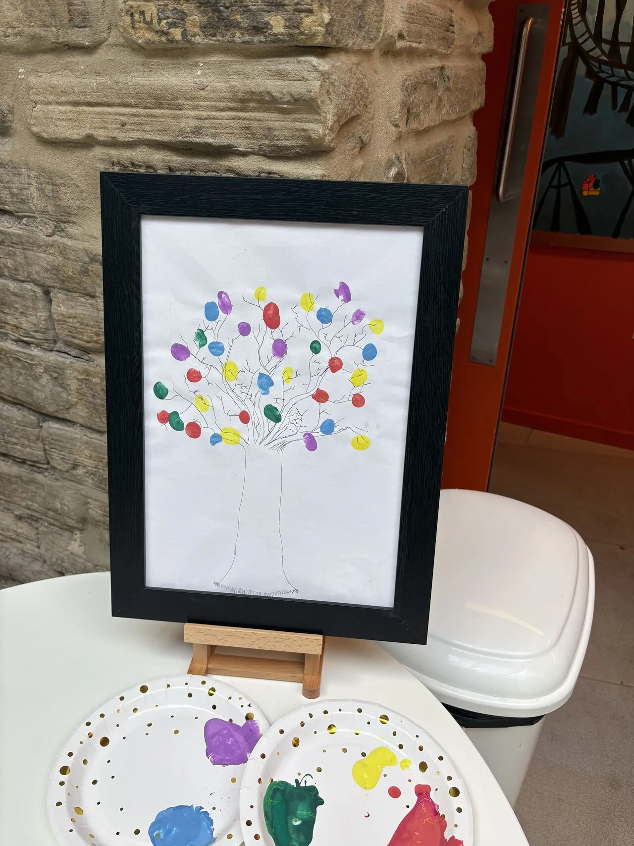 A drawing of a tree with lots of different coloured fingerprints on it