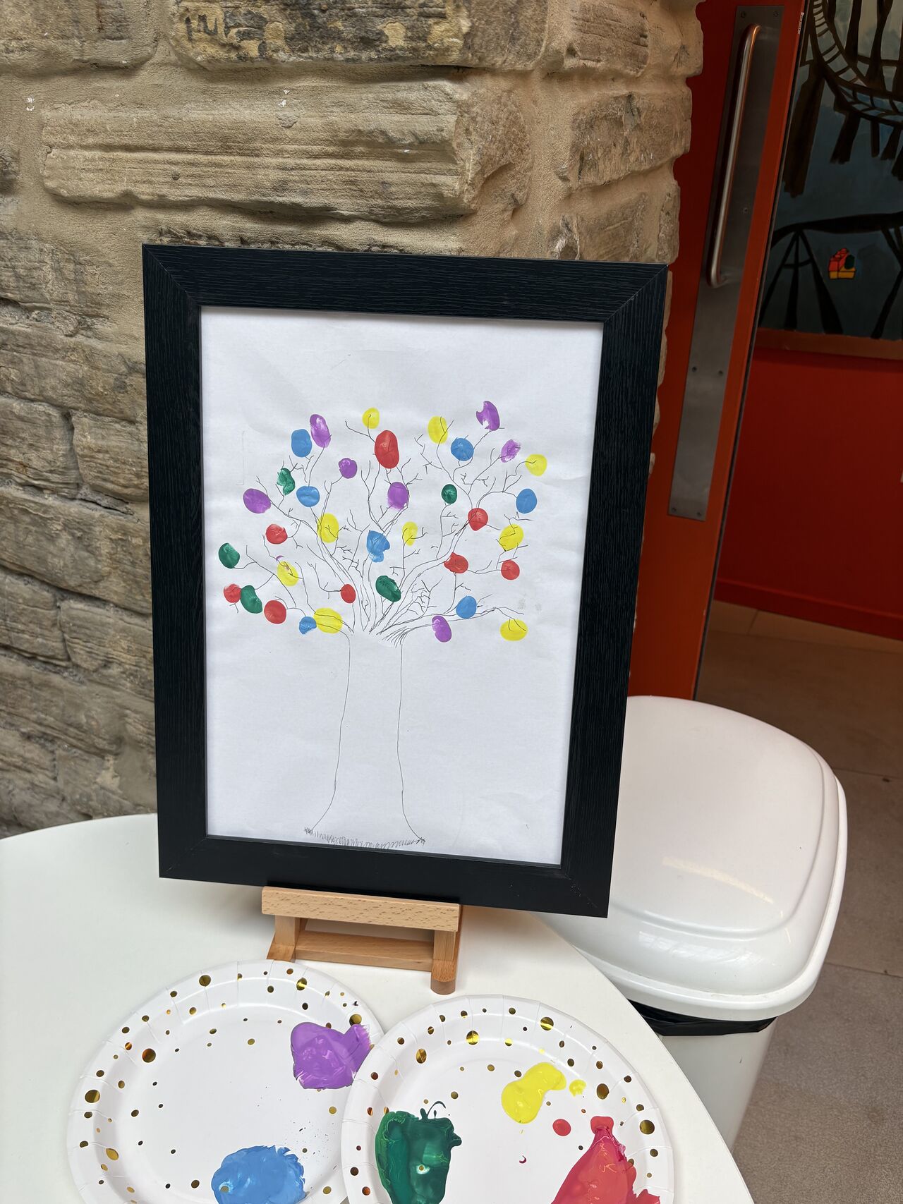 A drawing of a tree with lots of different coloured fingerprints on it